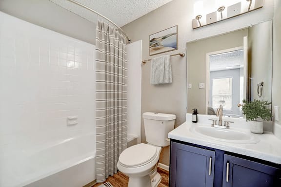 Bathroom with white vanity and tub shower combo at Peaks at Live Oak Apartments, San Antonio