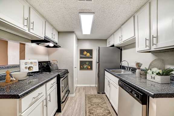 A kitchen with black countertops and white cabinets.