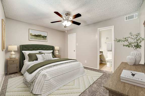 A bedroom with a large bed and a ceiling fan.