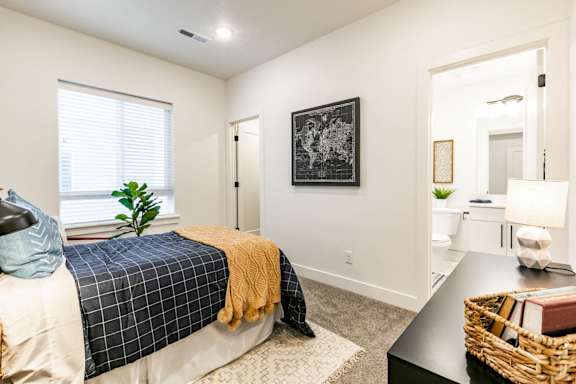 a bedroom with a bed and an open door leading to a bathroom