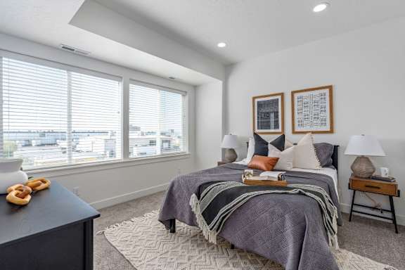 a bedroom with a bed and two windows