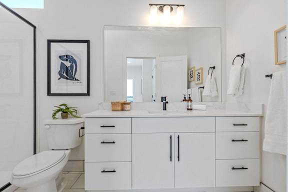 bathroom with a toilet, sink, and mirror