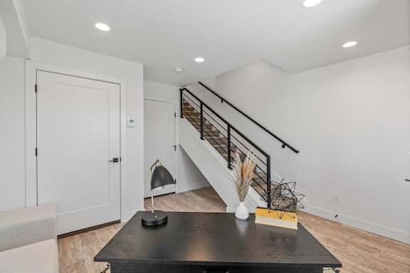 a living room with a staircase and a table and a door