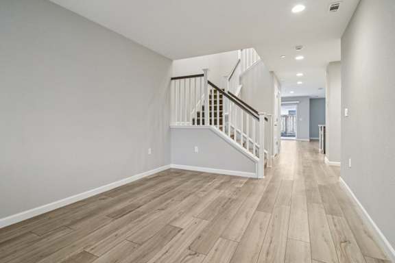 Family room with a staircase and wood flooring.