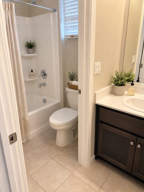 A white toilet in a bathroom with a white shower curtain.