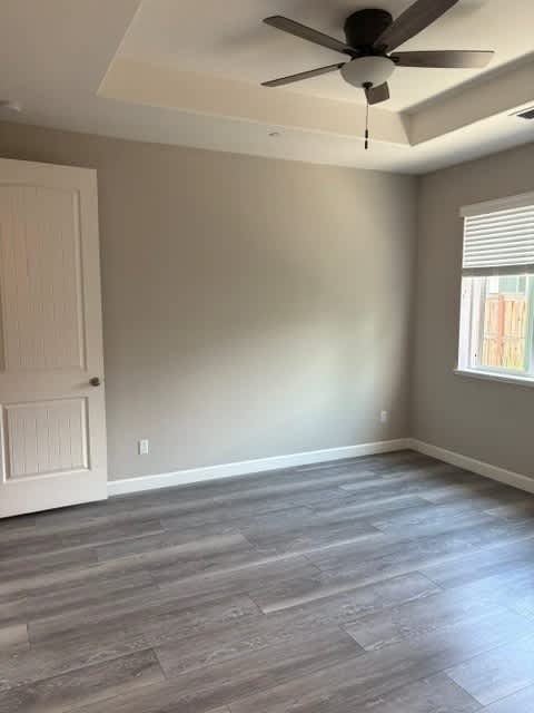 A room with a ceiling fan and a door.