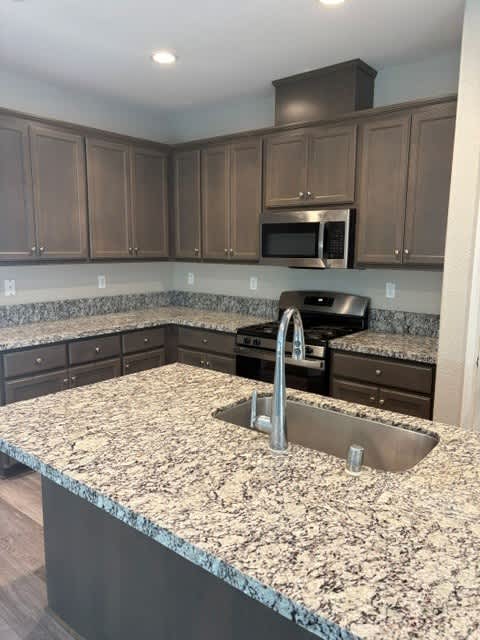 A kitchen with granite countertops and wooden cabinets.