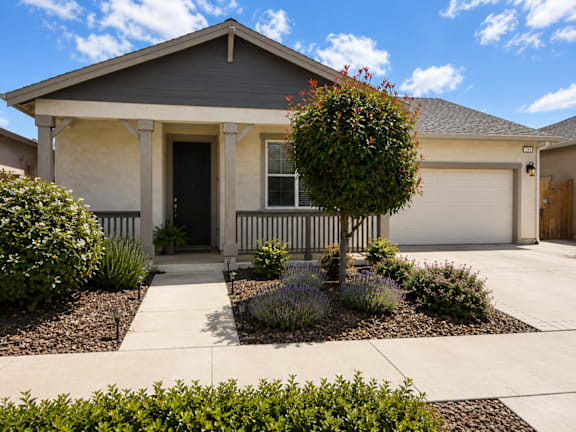 A house with a grey roof and a white garage door.