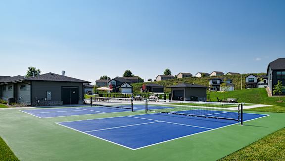 A tennis court with a blue surface and green border.