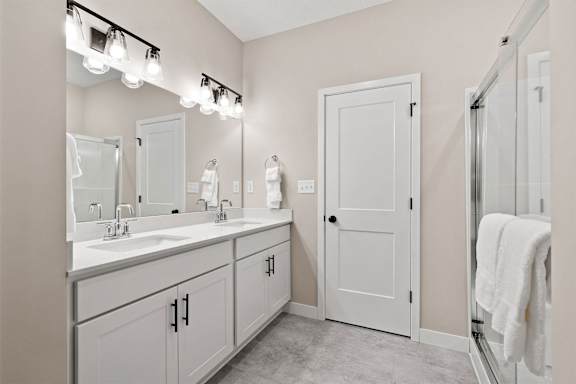 a bathroom with two sinks and a shower and a mirror