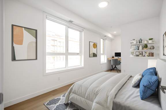 A bedroom with a large bed and a painting on the wall.