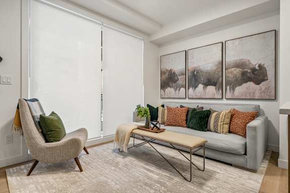 A living room with a chair, a couch, and a table.