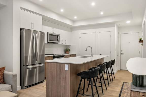 A modern kitchen with a stainless steel refrigerator and a white countertop.