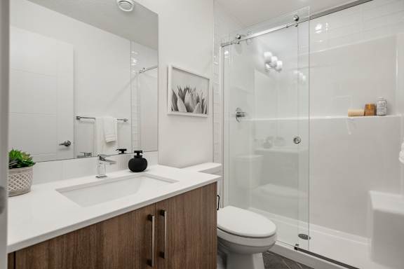A modern bathroom with a white countertop and a white toilet.