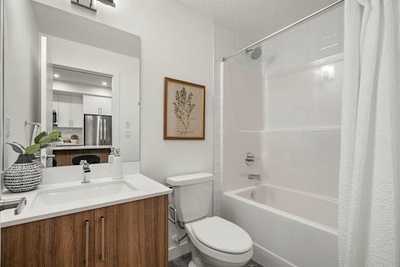 A bathroom with a white tub, toilet, and sink.