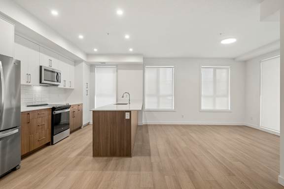A kitchen with wooden floors and stainless steel appliances.