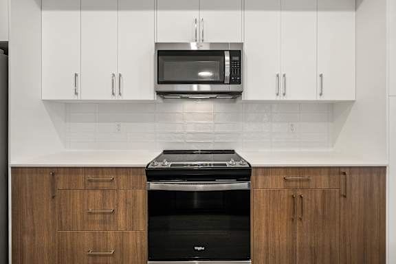 A kitchen with a black oven and white cabinets.