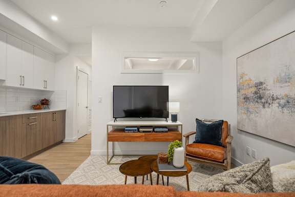 A modern living room with a television, a chair, and a table.