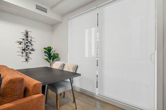 A dining room with a table and chairs.