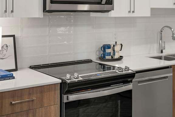 A modern kitchen with a stainless steel oven and white countertops.