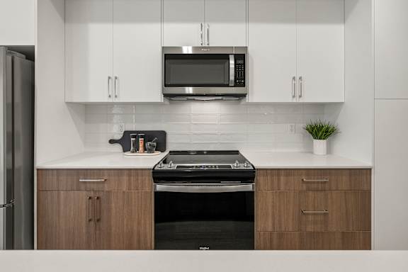 A modern kitchen with a stove top oven and microwave above it.