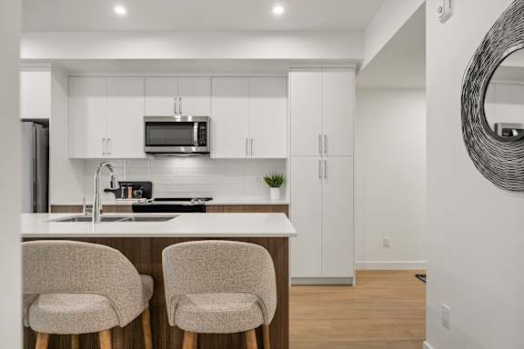 A modern kitchen with white cabinets and a white countertop.