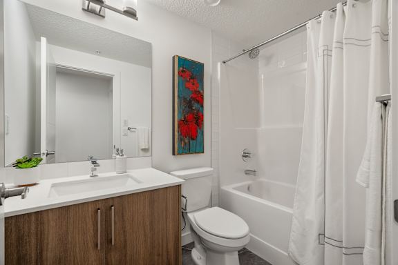 A bathroom with a white toilet, sink, and bathtub.