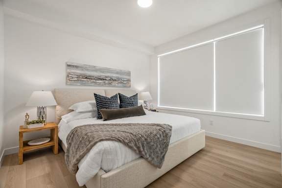 A bedroom with a large bed and a wooden nightstand.