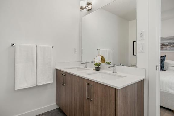 A bathroom with a white counter and a white sink.
