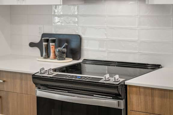 A modern kitchen with a black stove top oven.