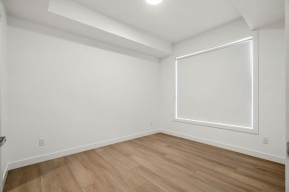 A room with a large window and wooden flooring.