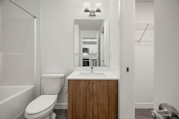 A white bathroom with a toilet, sink, and bathtub.