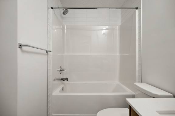 A white bathroom with a tub, toilet, and sink.