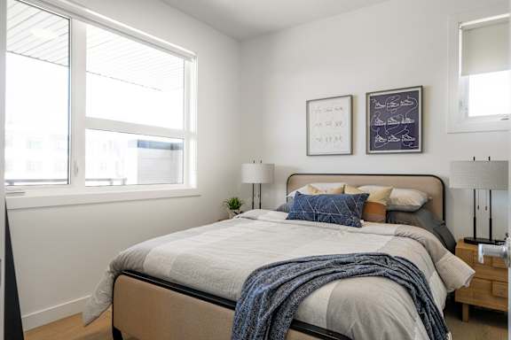 A bedroom with a large bed and two framed pictures on the wall.