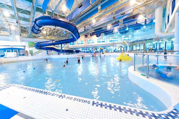 A large indoor pool with people swimming and a yellow float.