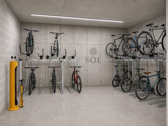 A bicycle parking area with a yellow post and bicycles on the racks.