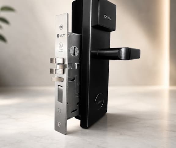 A black Orbi device is mounted on a wall.