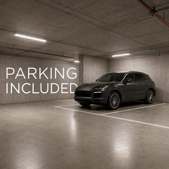 A car is parked in a parking garage with the words "PARKING INCLUDED" on the wall.