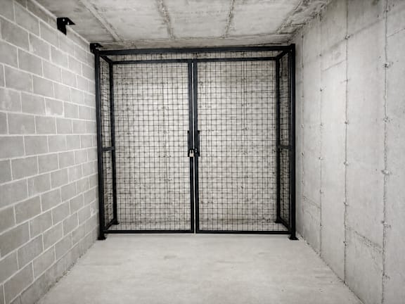 A black gate is closed in a concrete room.