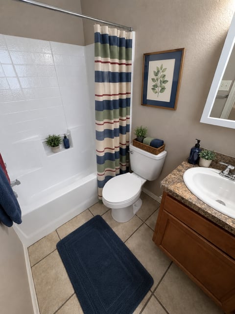 A bathroom with a toilet, sink, and shower curtain.