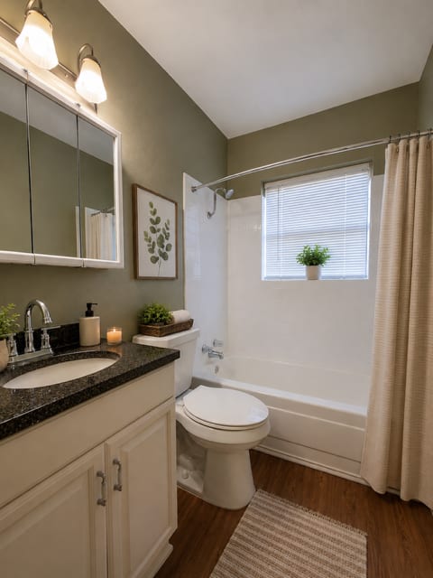 A bathroom with a toilet, sink, and shower.