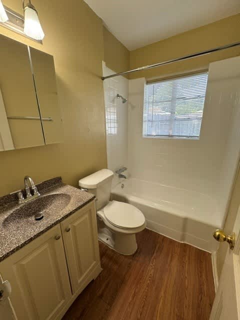 A bathroom with a toilet, sink, and bathtub.