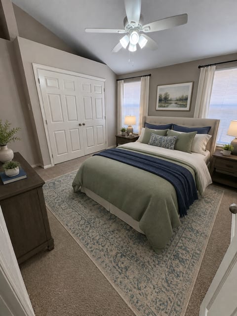 A bedroom with a bed, a dresser, and a ceiling fan.