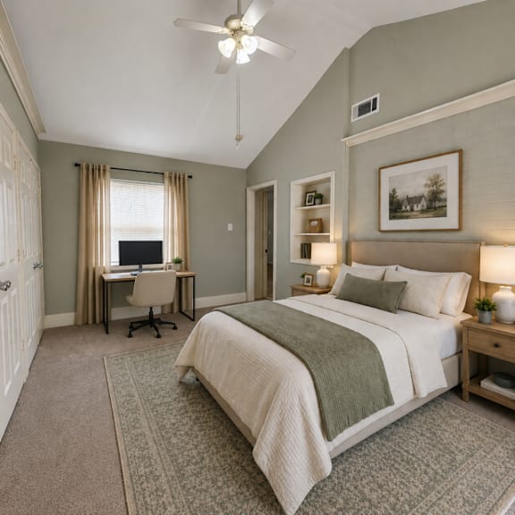 A bedroom with a large bed, a desk with a computer, and a ceiling fan.