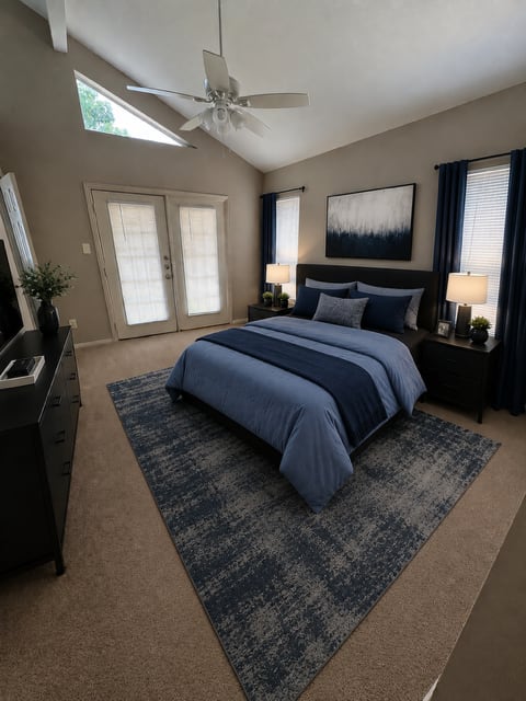 A bedroom with a bed, dresser, and ceiling fan.
