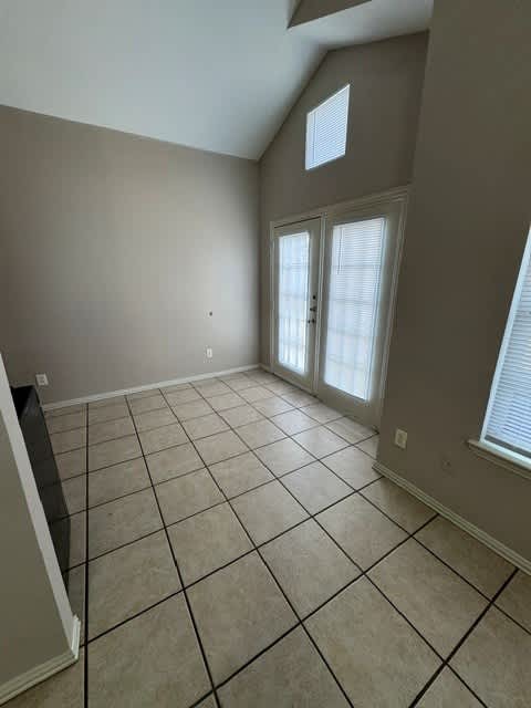 A room with a tiled floor and a window with blinds.