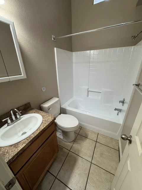 A bathroom with a toilet, sink, and bathtub.