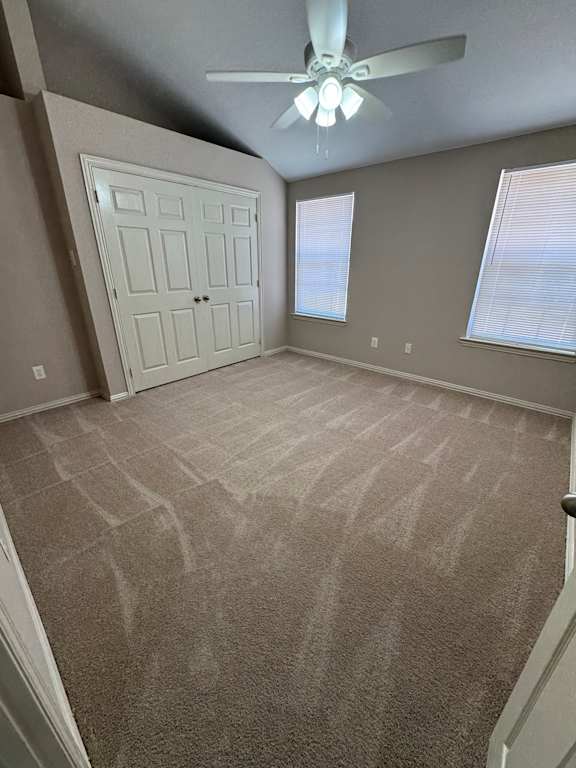 A room with a ceiling fan and a door.