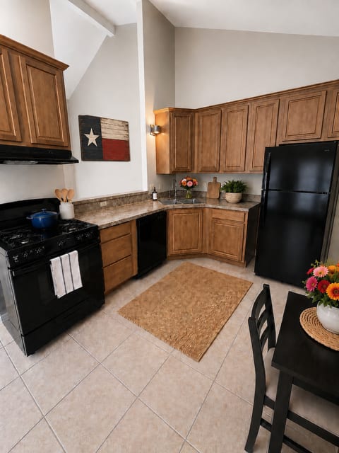 A kitchen with black appliances and wooden cabinets.