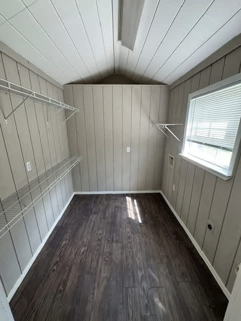A room with wood floors and a window with blinds.